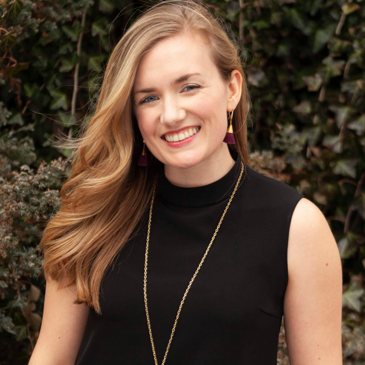 Portrait of Erin Houston, co-founder of wearwell ethical sustainable subscription membership personal styling service, wearing black mock neck sleeveless top, long gold drop necklace, and burgundy gold tassel earrings. 