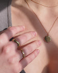 A model is wearing the Organic Ring, Squiggle Ring, and Vision Necklace. All of the jewelry is gold. 